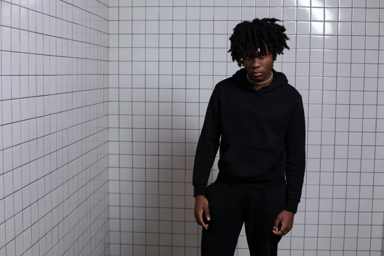 a man is standing in a bathroom with all black hair