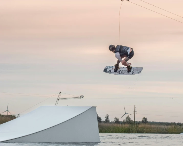 a man that is jumping over the water with some skiis