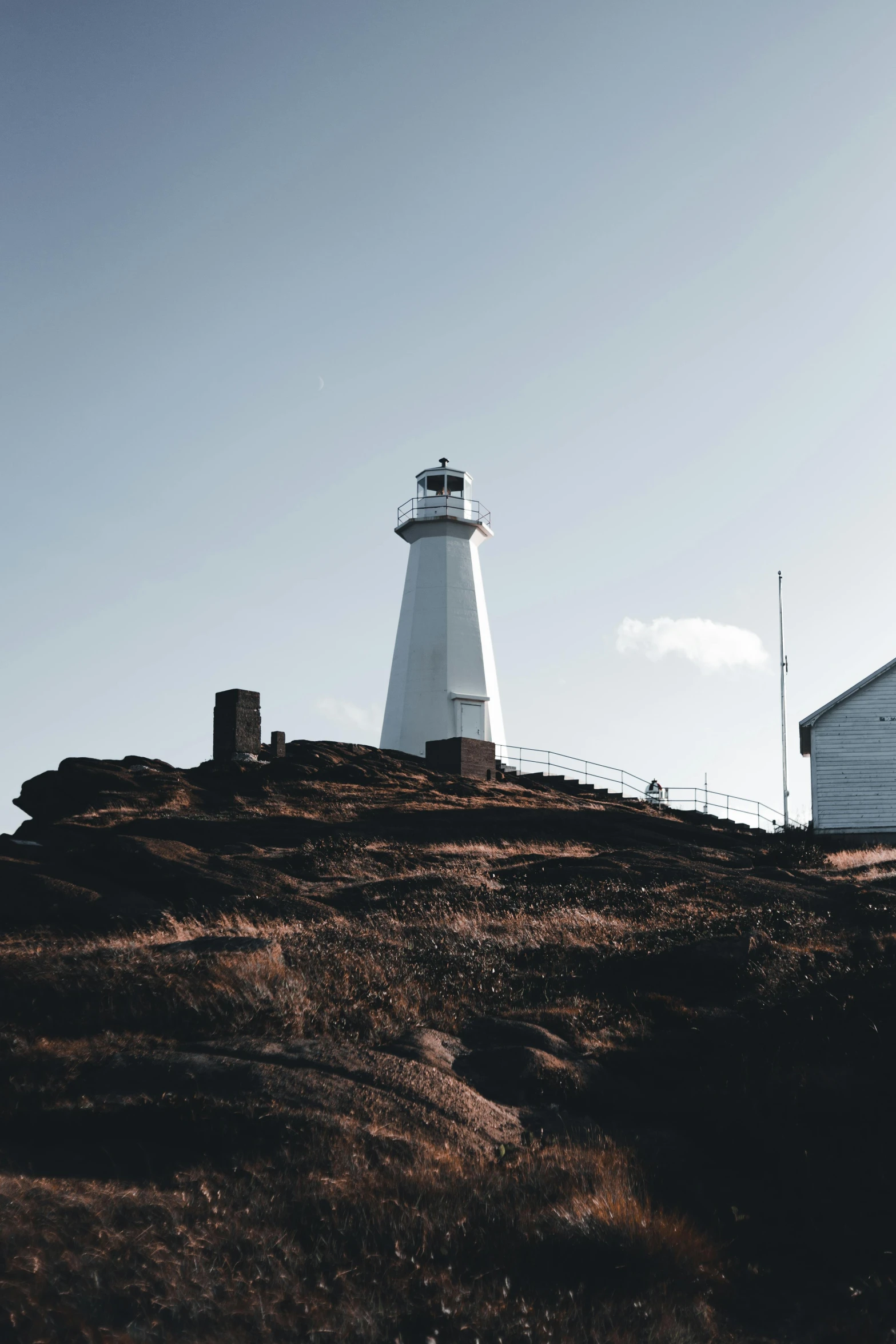 lighthouse with brown landscape on clear day