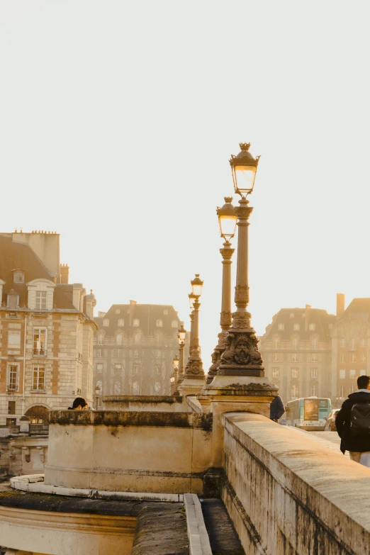 a lamp post on the side of a bridge overlooking some buildings