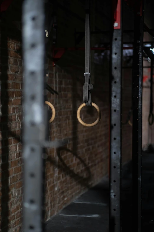 two circle - shaped rings attached to two bars next to a brick wall