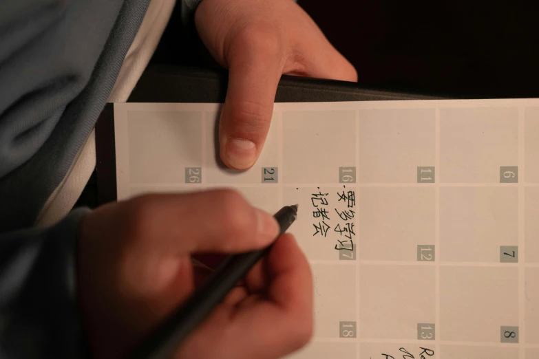 a person writing chinese on a calendar