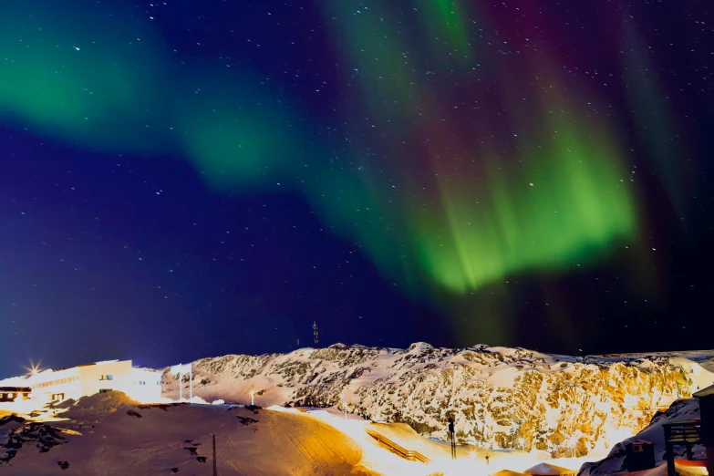 the aurora is glowing in the sky above a mountain top