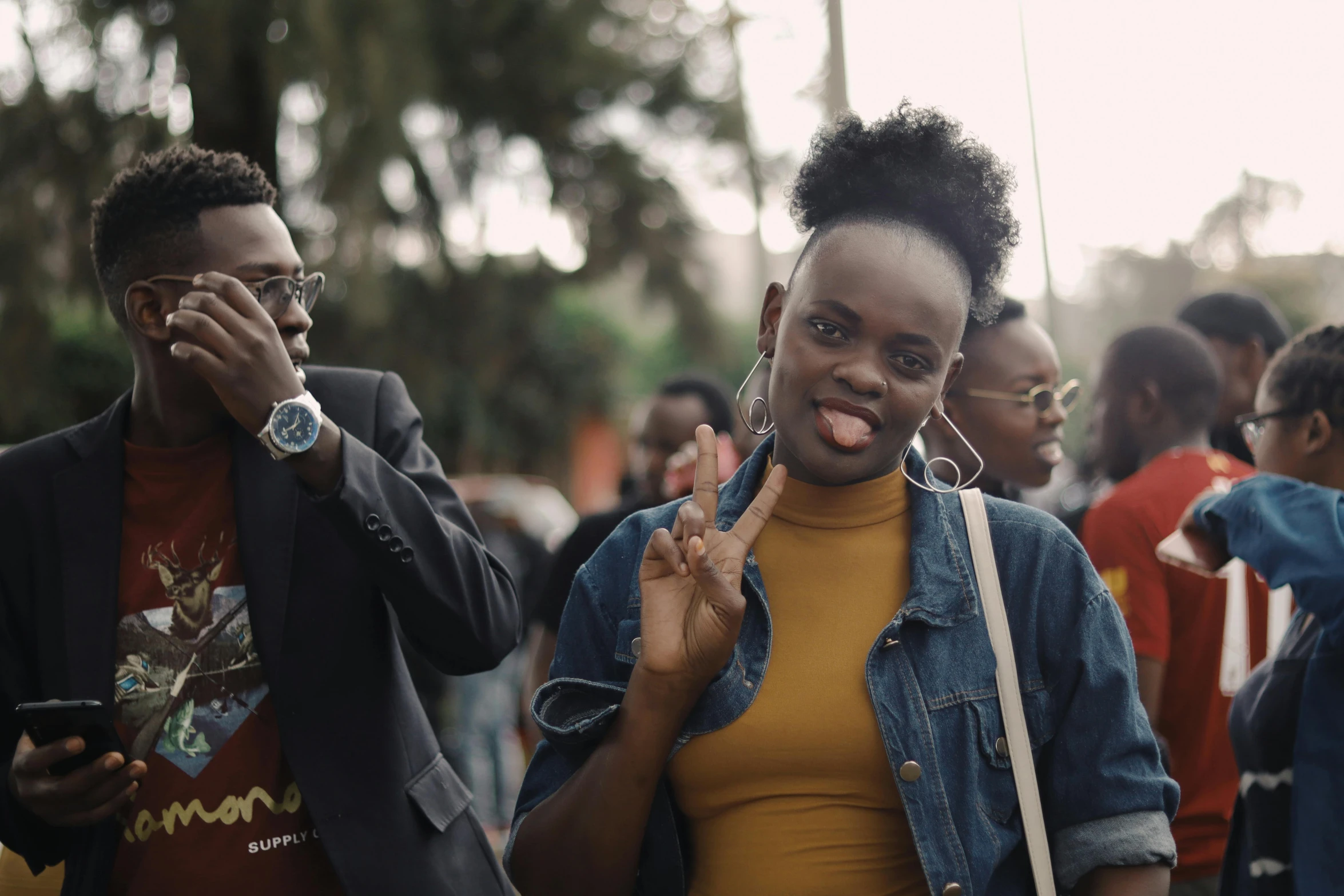 the woman shows off her large earring while walking through the crowd