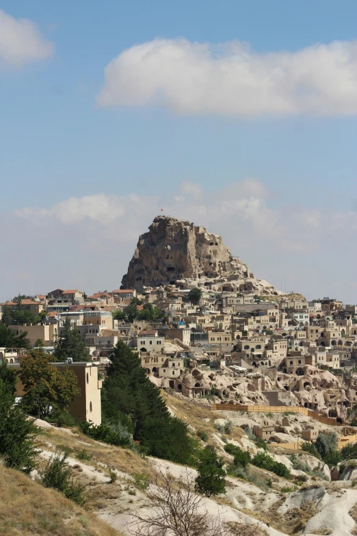 a view of a large city with rocky cliffs and rocks