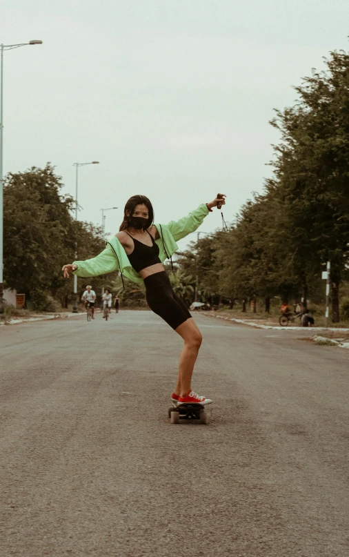 a skateboarder is seen riding her board through the street