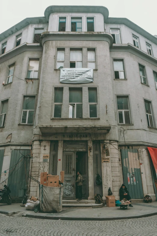 a tall building with several doors and a few people