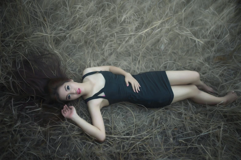 a girl laying in hay on the ground