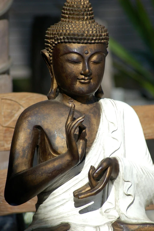 an ancient buddha statue sitting on top of a bench