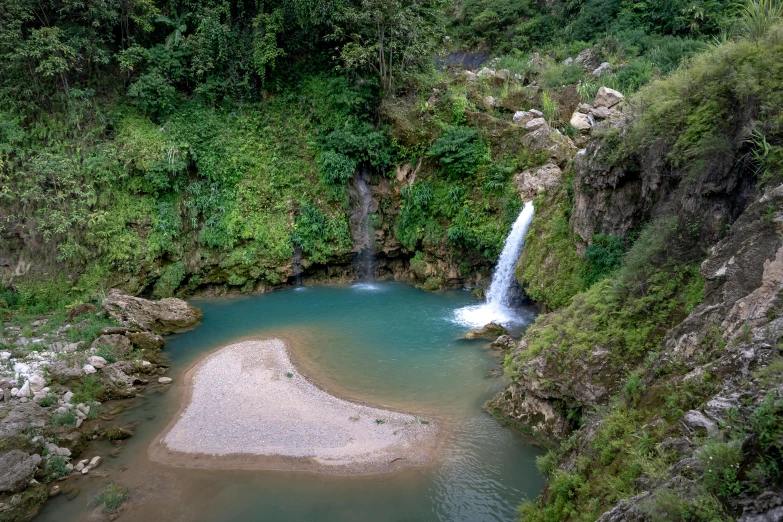 the beautiful waterfalls surrounded by greenery in a valley