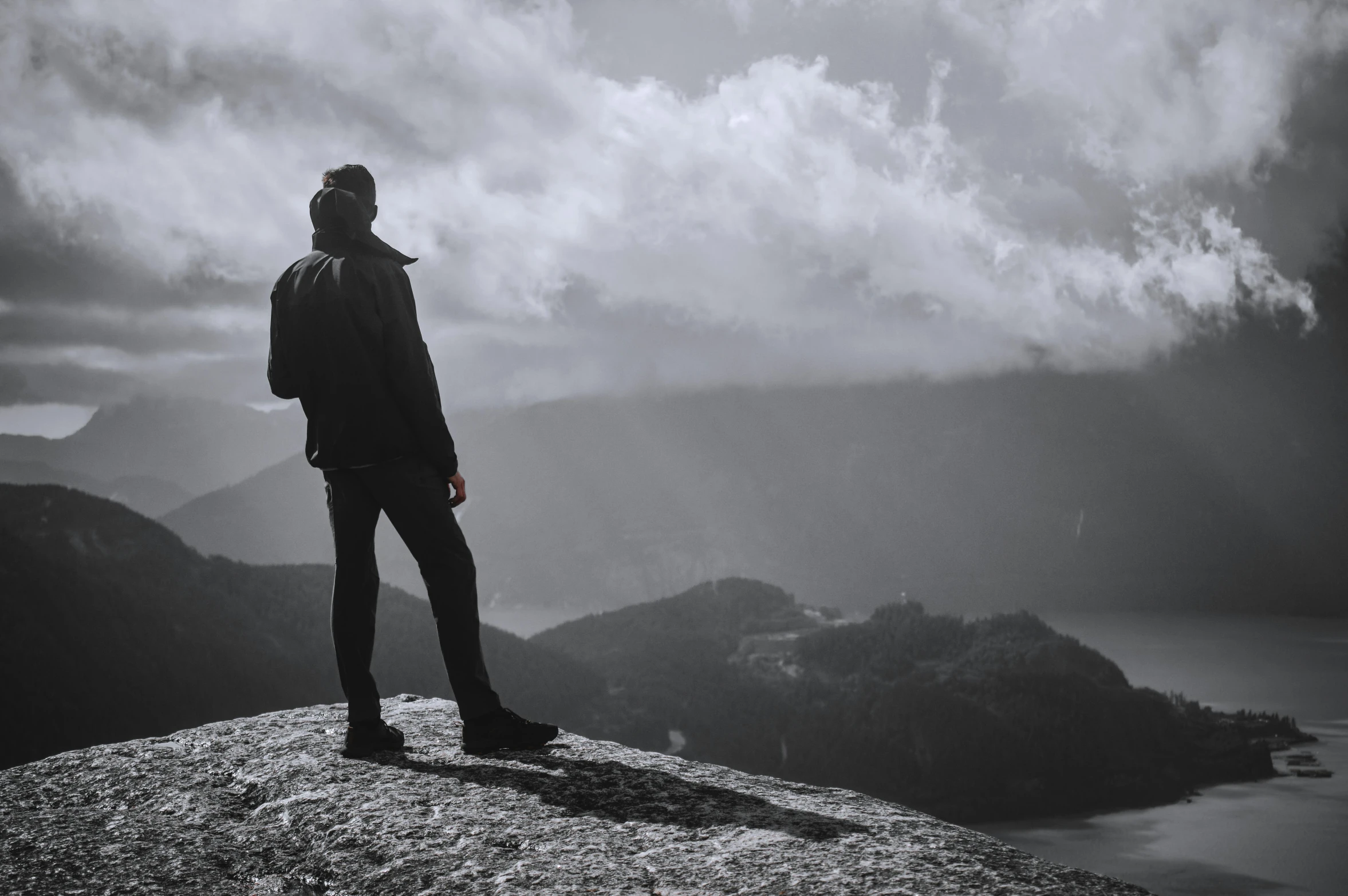 the man is standing on the top of a rock