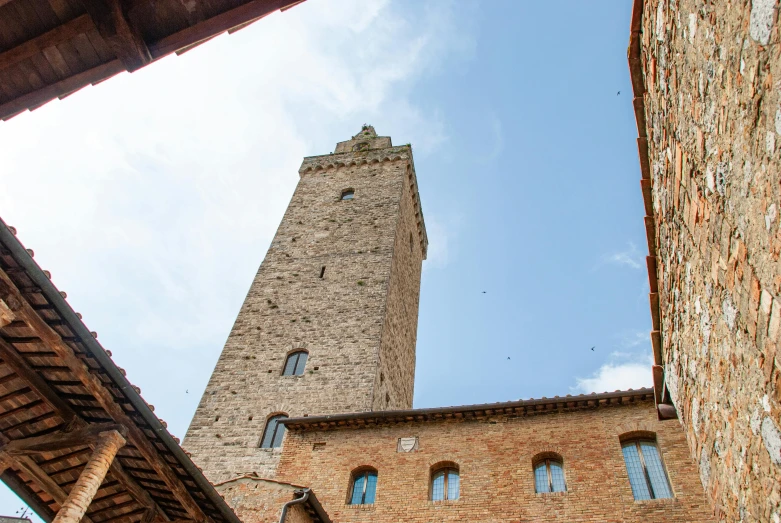 an old brick tower next to two other tall buildings