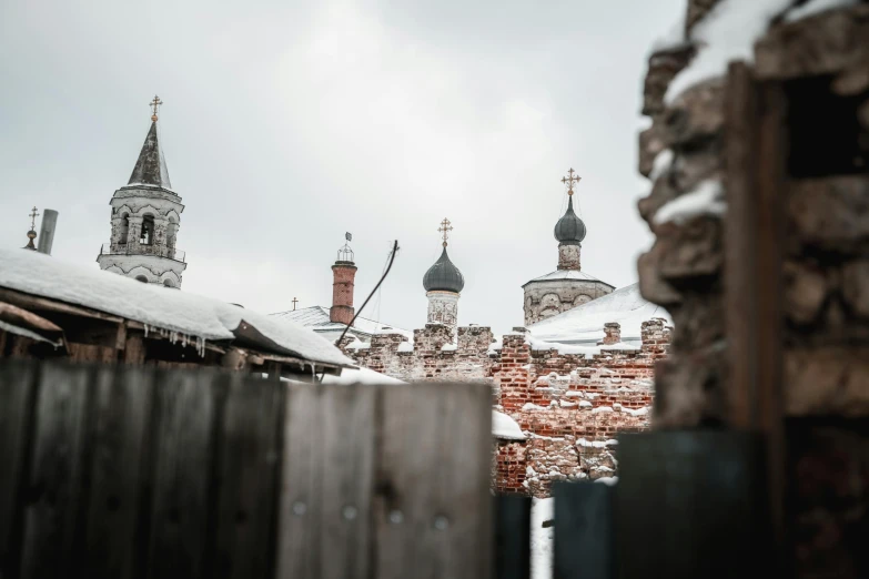 an old building in the snow with some roofs covered in snow