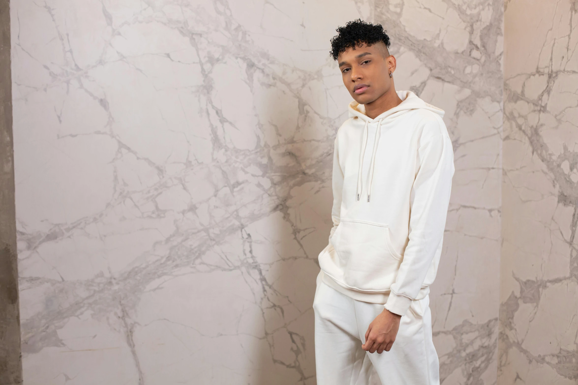 a man stands in front of a marble wall