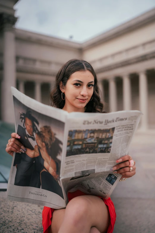 a woman is holding up her news paper