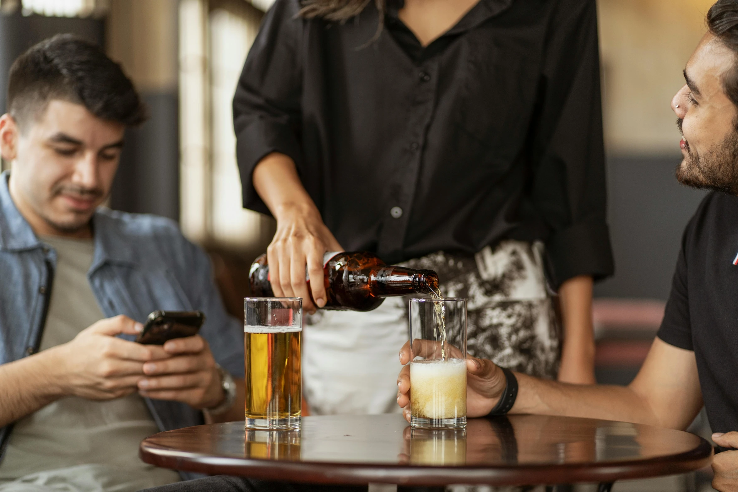 two men and a woman are sitting at a table