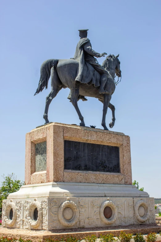 a statue is located near a large grassy area