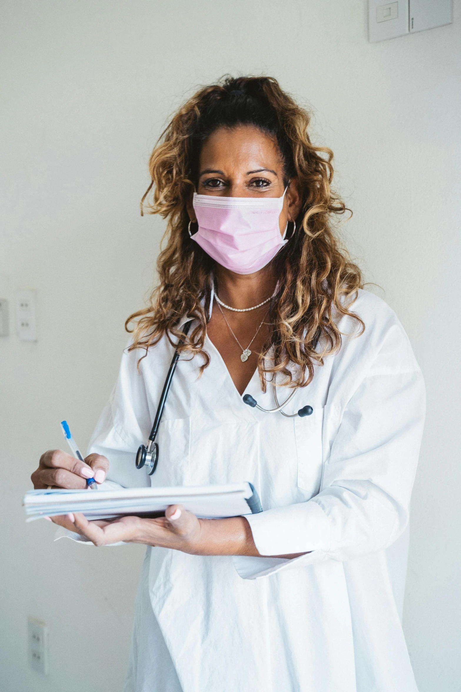 a woman with glasses wearing a face mask while writing