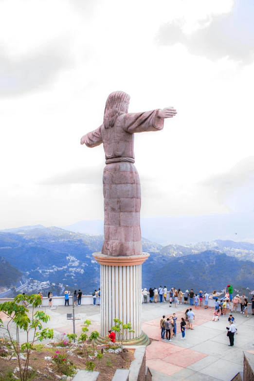 people standing around and near a tall statue