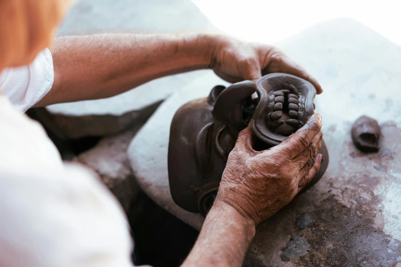 an old hand working on soing on the rock