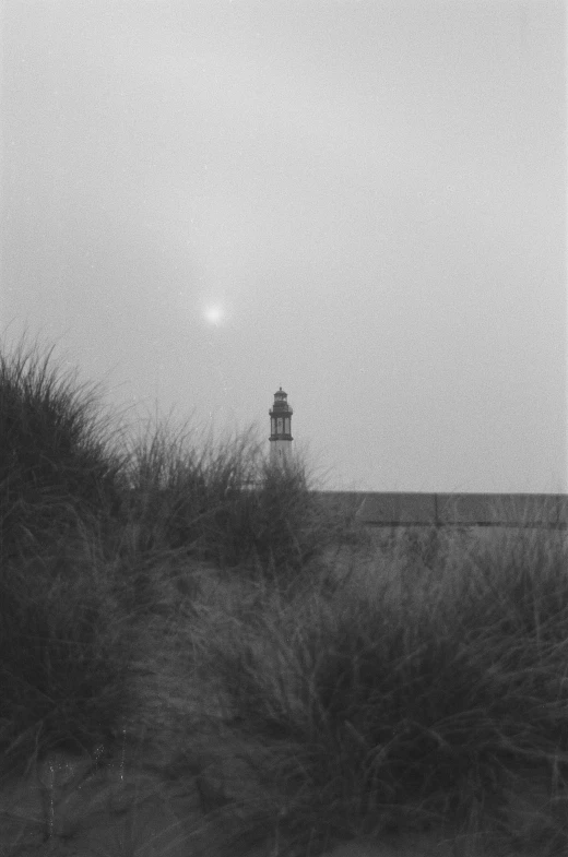 an old po of a lighthouse by some water