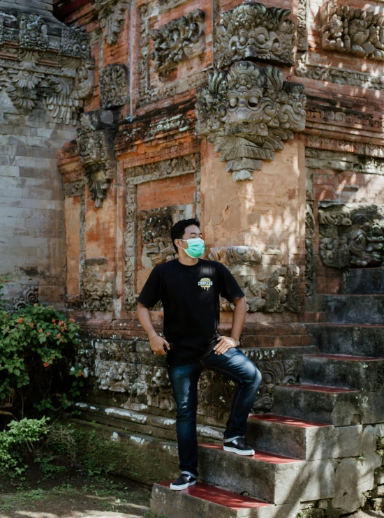 man sitting on the steps wearing surgical mask