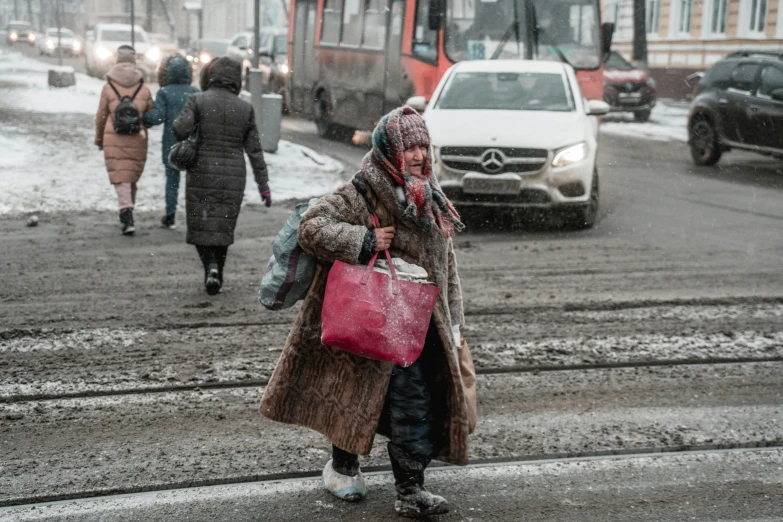 a woman wearing winter clothes with bags and walking