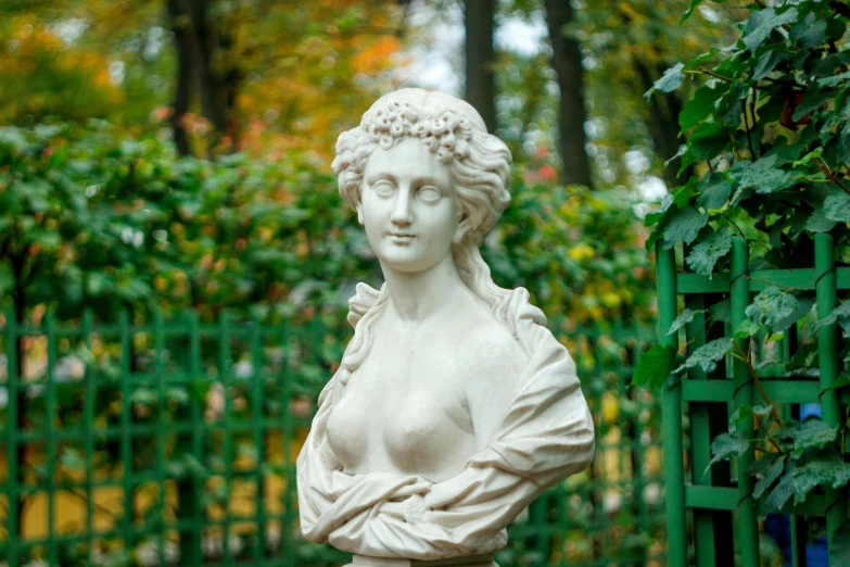 statue of woman posed in front of a gate