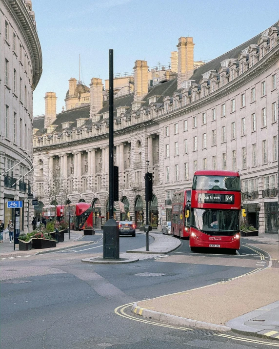 double decker buses traveling through the streets of london