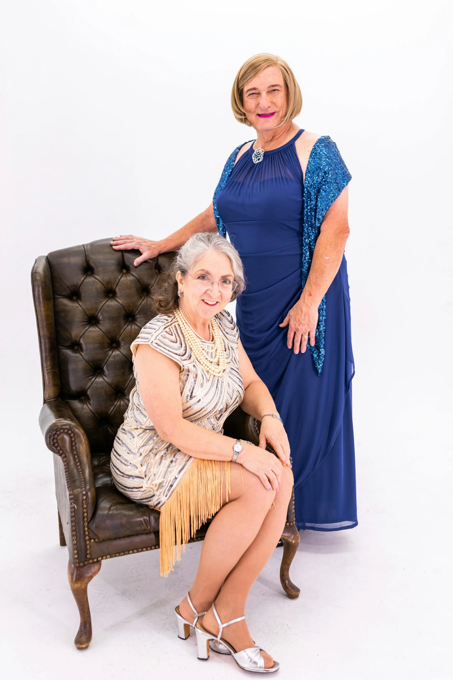 two women pose in dresses that are very similar to each other