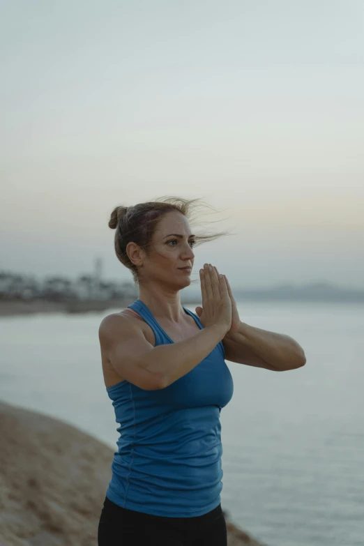 a woman doing yoga on the beach