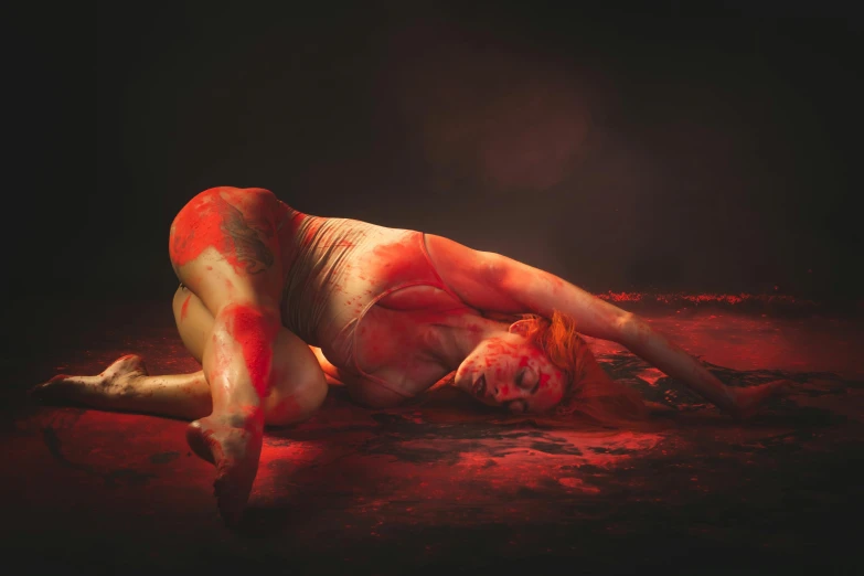 a person with smeared  on their body laying on the ground