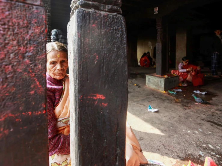 an old woman looking out from under a black structure