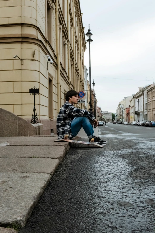 a boy sits on his skateboard in the middle of a dle