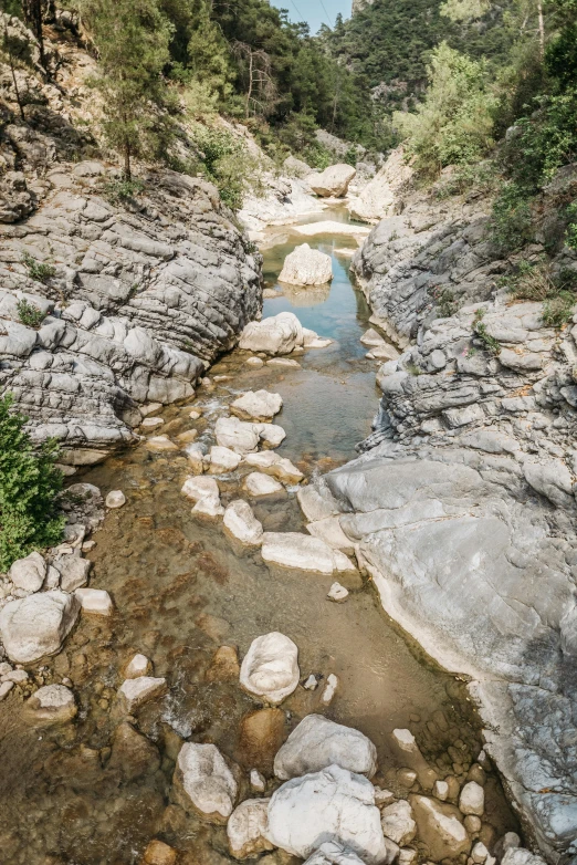 some rocks in the water with a bridge behind