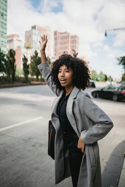 a young woman waves from the side of a road