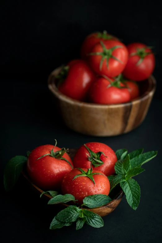 a bunch of tomatoes in a wooden bowl on the table