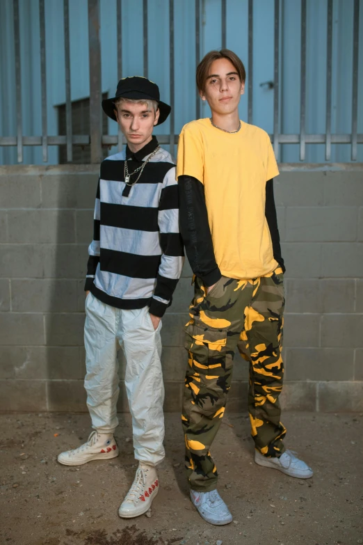 a young man standing next to a tall boy in matching clothing