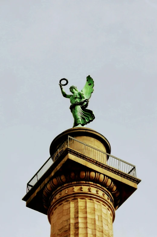 the statue stands tall on top of a large tower