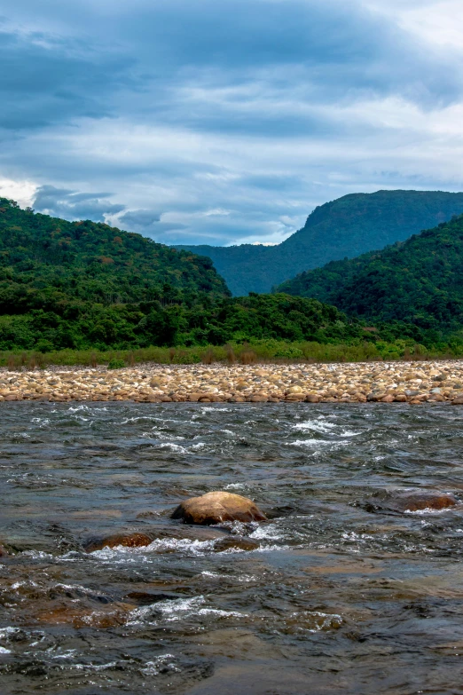 a man in a boat on the water near mountains