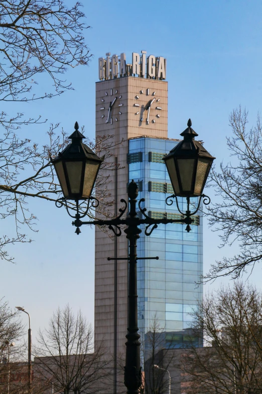 street lamps are next to the building with clocks