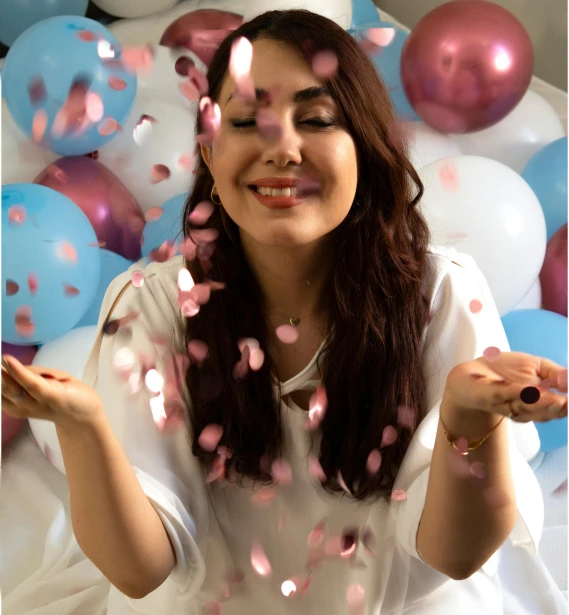 a woman in white shirt throwing balloons