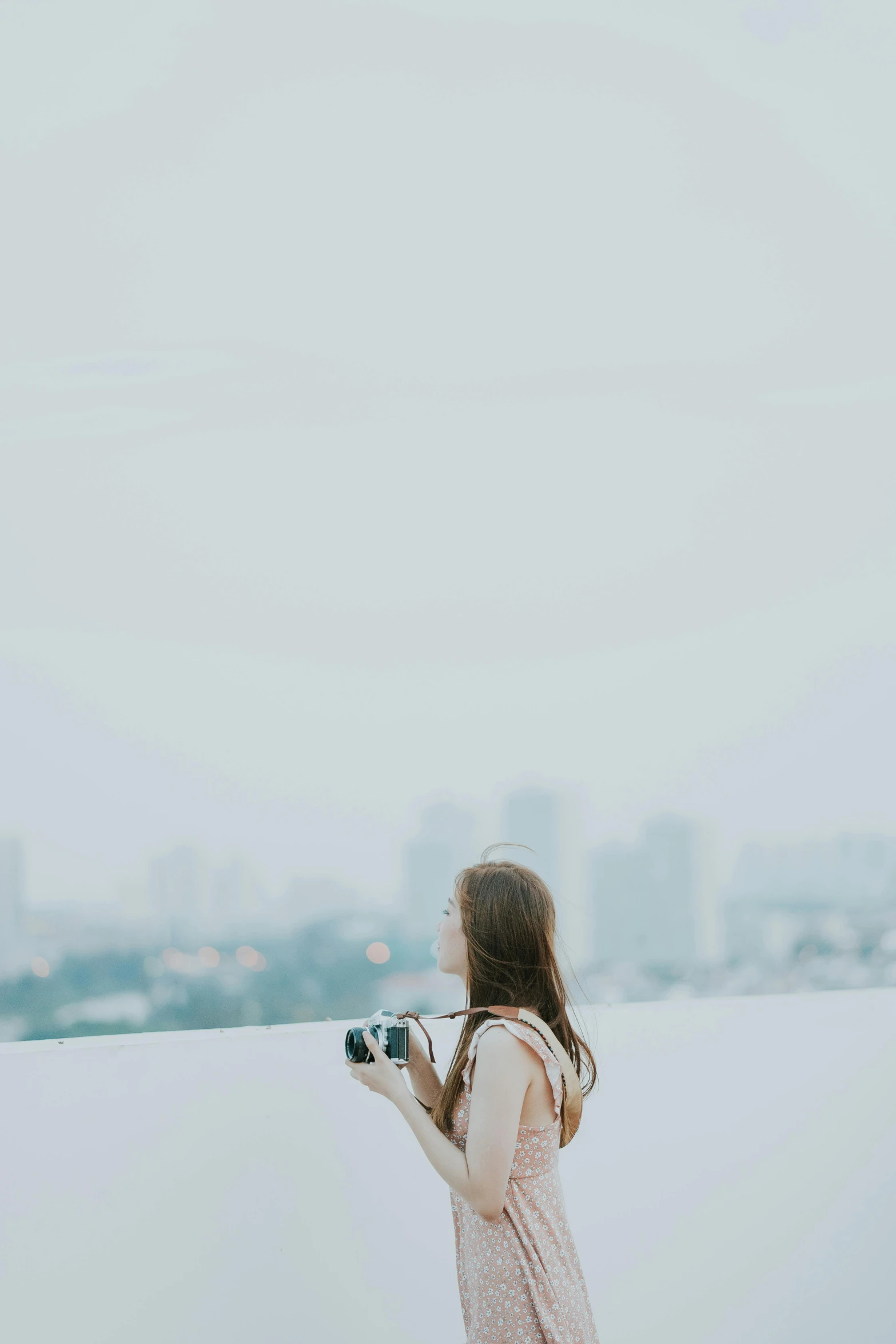 a woman standing in front of a window while holding a camera