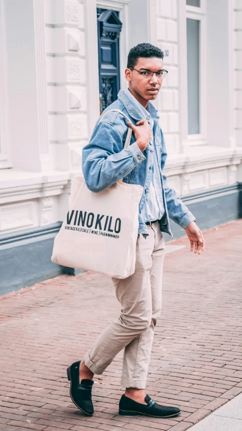 a man with a blue jacket is carrying a white bag