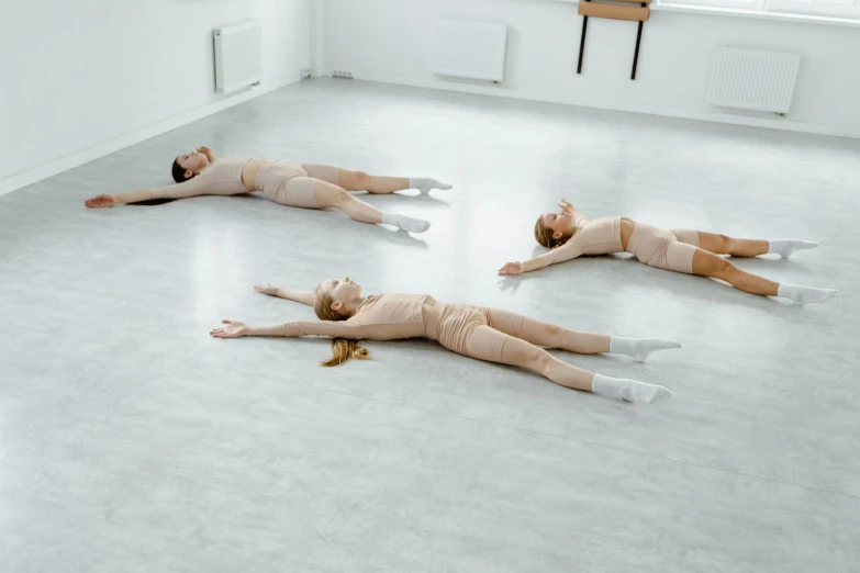 three dancers stretch out in their  outfits