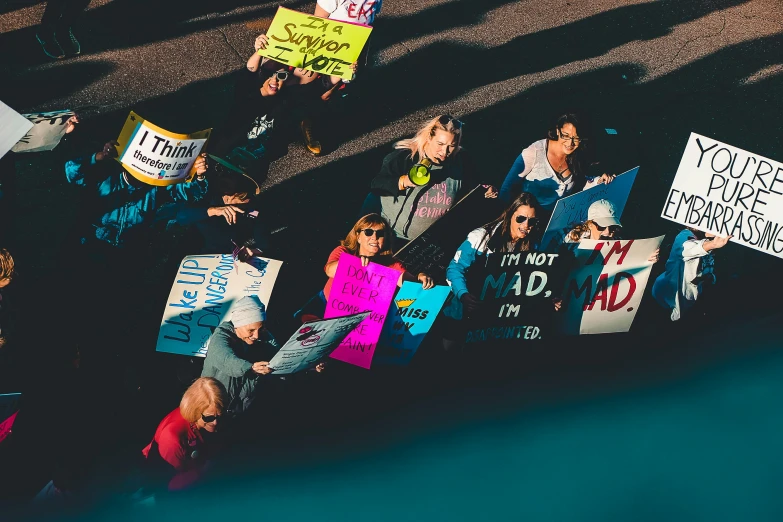 people sitting on the ground with signs and placards