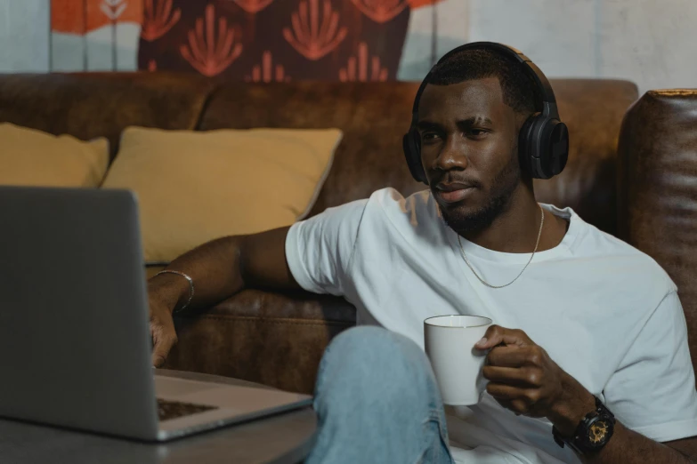 a man with headphones holding a cup
