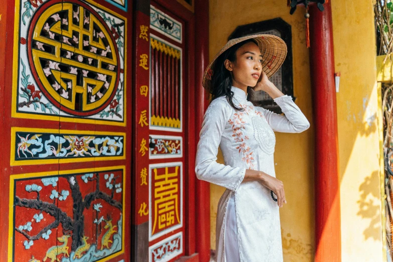 an asian woman stands outside a chinese style building