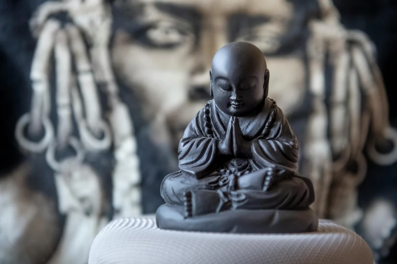 a small buddha statue sitting on top of a white table