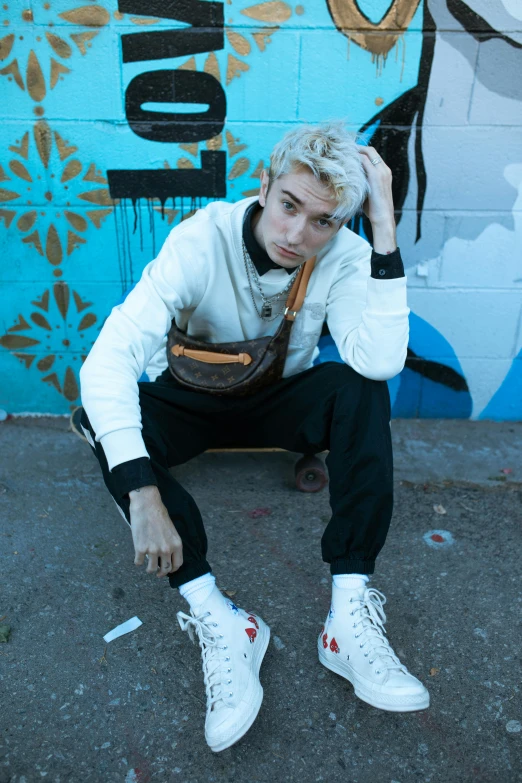 young man in white shirt and jeans and leather messenger bag